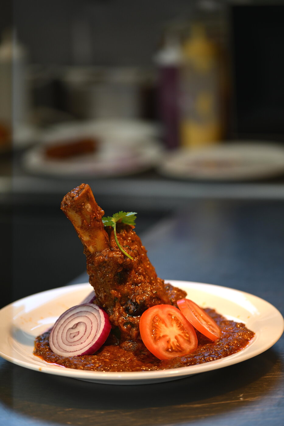 Slow-cooked lamb shank in rich masala at Curriocity